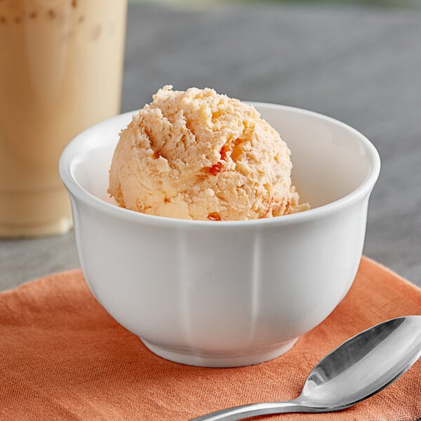 A bowl of Oringer orange pineapple ice cream with a spoon.