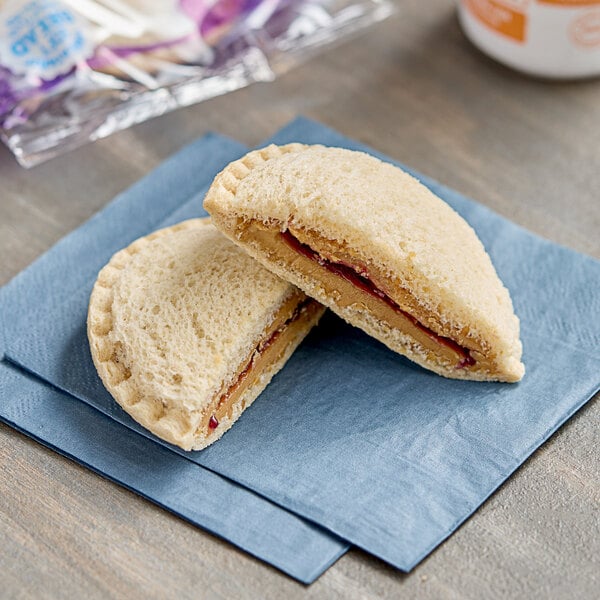 A Smucker's Uncrustables peanut butter and jelly sandwich on a napkin.