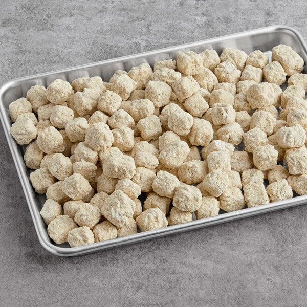 A tray filled with Fred's Breaded Hot Pepper Cheese Cubes on a table.