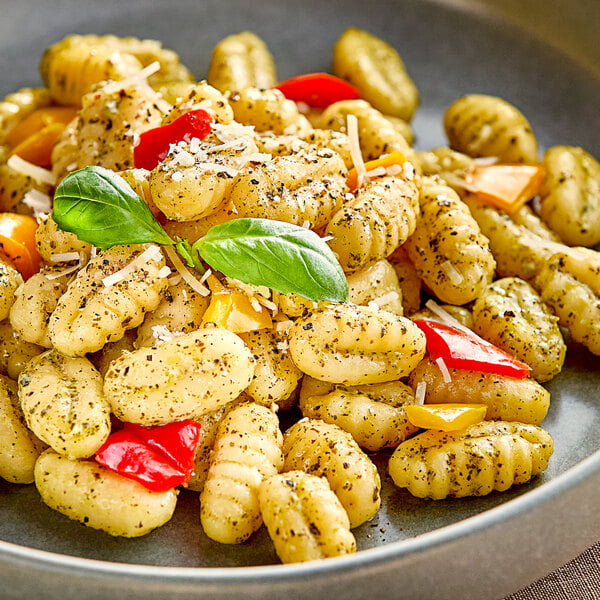 A plate of Seviroli potato gnocchi with peppers and herbs.