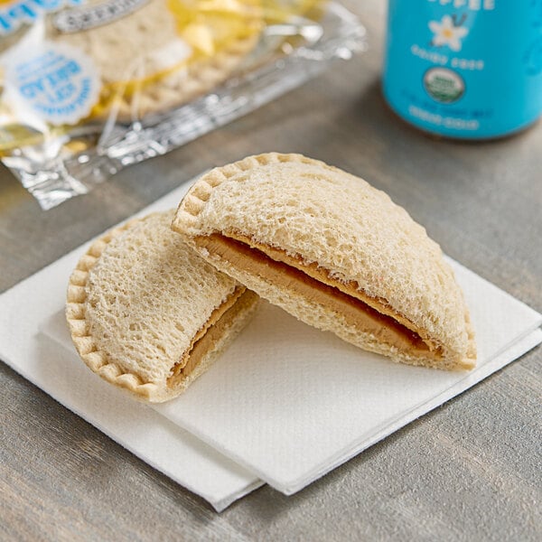 A Smucker's Uncrustable sandwich with peanut butter on a napkin.