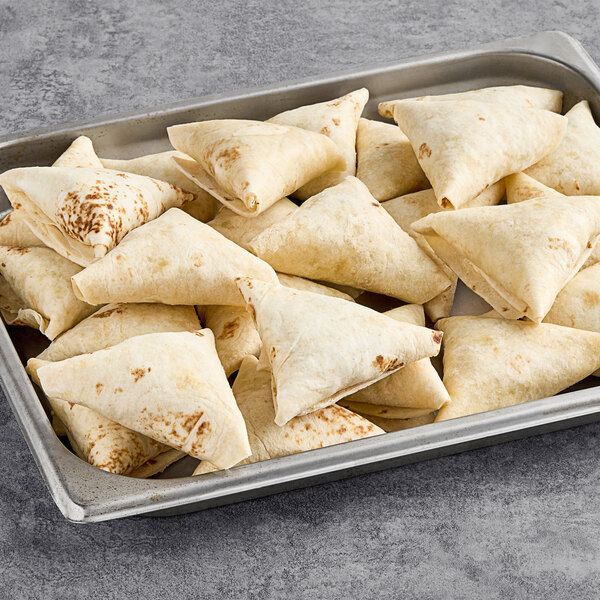 A tray of Maple Leaf Farms Duck and Pepperjack Quesadillas on a gray surface.