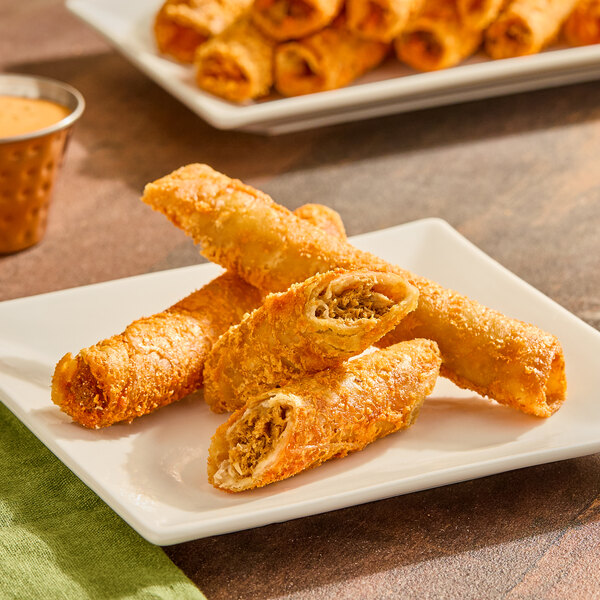 A plate of Posada Nashville Hot Crunchero rolled tacos with dipping sauce.