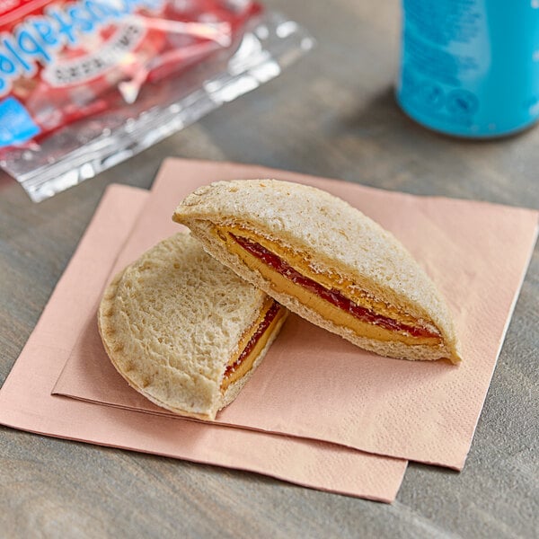 A Smucker's Uncrustables sandwich with peanut butter and jelly on a napkin.