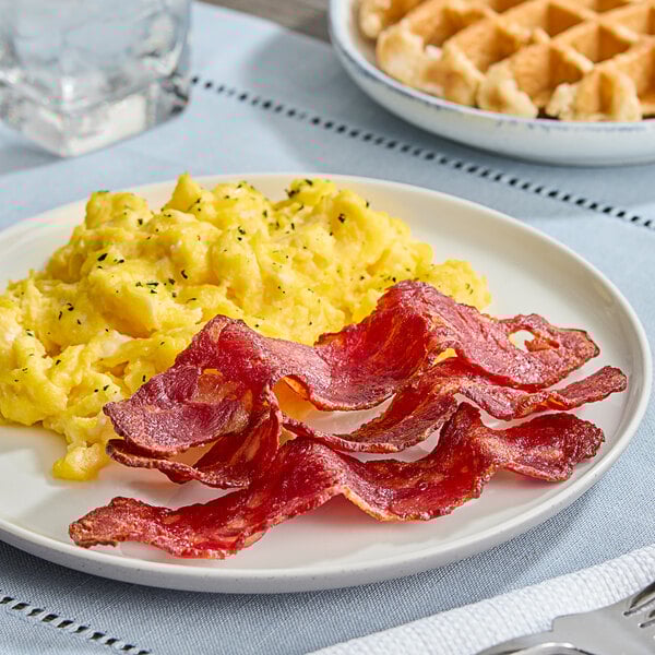 A plate of scrambled eggs and Maple Leaf Farms Duck Bacon.