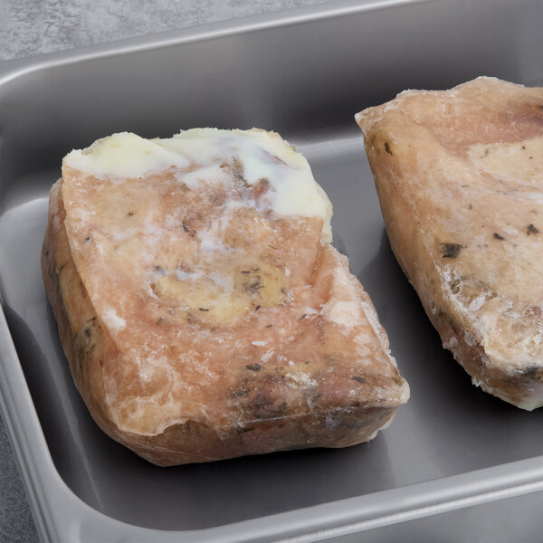 A tray of frozen Maple Leaf Farms Fully Cooked Bone-In Duck Leg Confit.