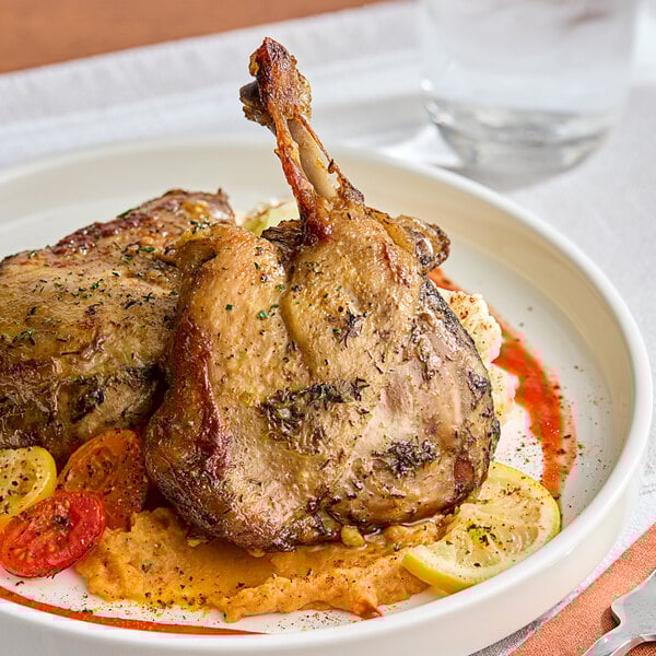 A plate of Maple Leaf Farms fully cooked duck leg confit on a table.
