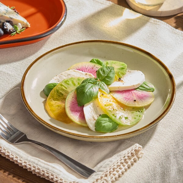 An Acopa Keystone granite gray porcelain plate with food on it and a fork and knife.