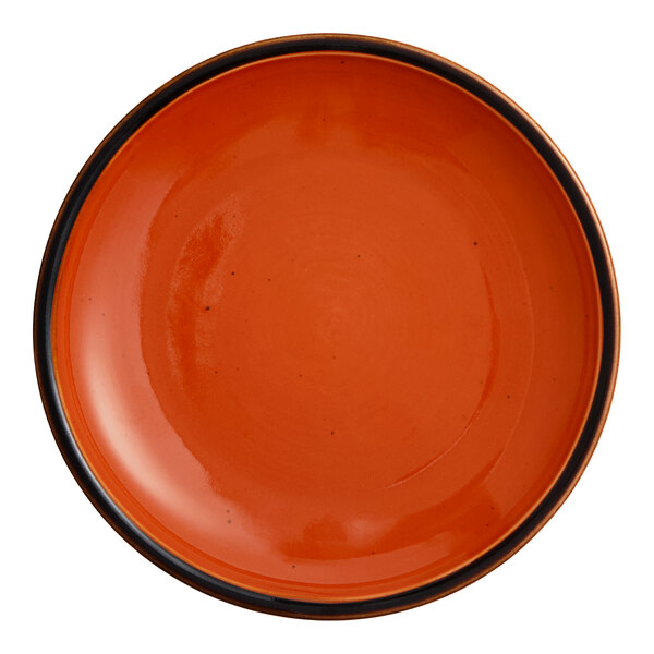 An orange Acopa Keystone porcelain coupe plate with a black rim.