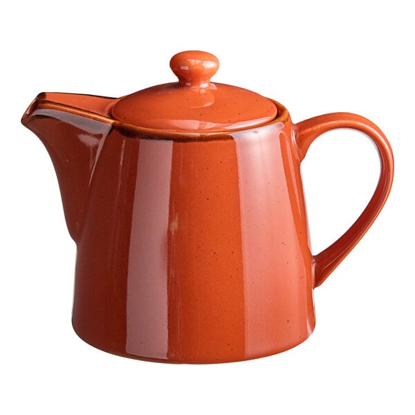 An Acopa Keystone Sedona Orange porcelain teapot with lid on a counter.