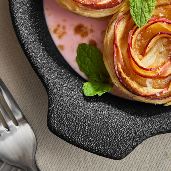 An Acopa Keystone porcelain casserole dish filled with food on a table with a fork.