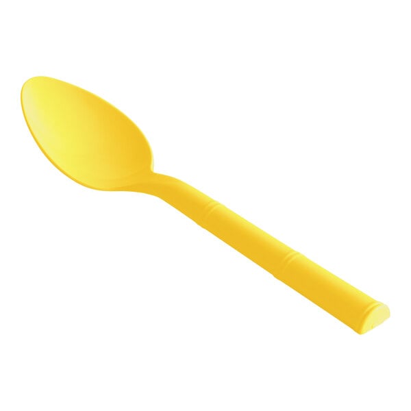 A close up of a yellow Design Specialties polycarbonate teaspoon.