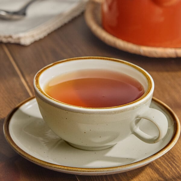 A granite gray porcelain cup filled with tea, placed on a matching saucer.
