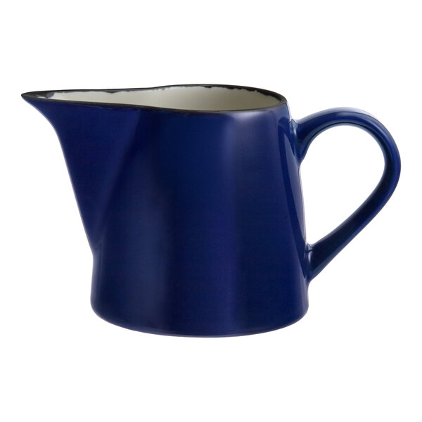 A blue porcelain creamer with a handle and spout.
