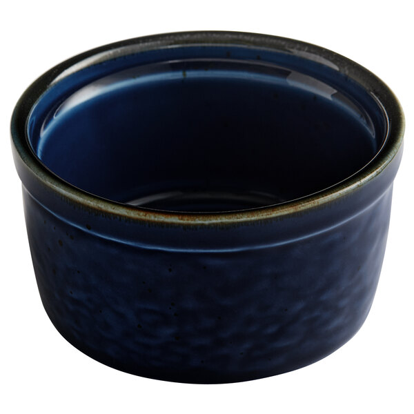 An Acopa Keystone Azora Blue porcelain ramekin with a rim on a table.