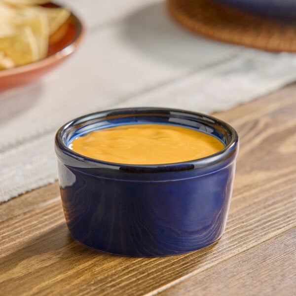 A small blue porcelain ramekin filled with a creamy orange sauce.