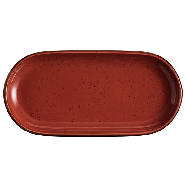 An Acopa Sedona Orange oval coupe platter with speckled specks on the table.