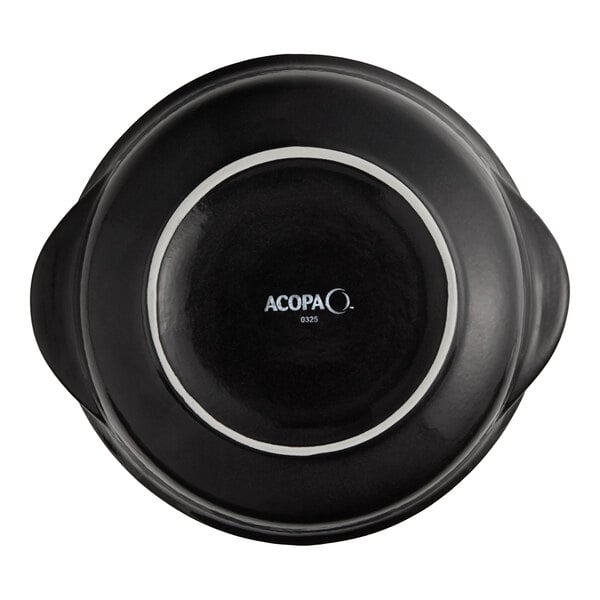 A close-up of a black Acopa Keystone porcelain onion soup crock with white lettering.