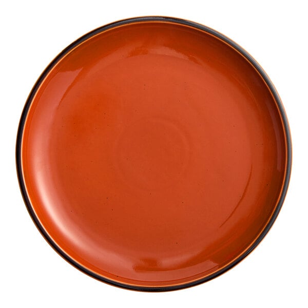 An orange Acopa Keystone porcelain coupe plate with a black rim.