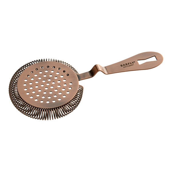 A close-up of a Barfly Deluxe Antique Copper Hawthorne Strainer with a handle and holes in it.