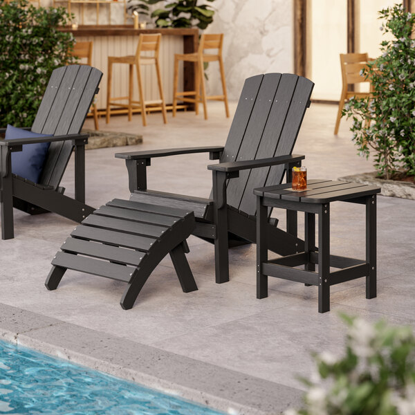 A black Lancaster Table & Seating Adirondack footrest with a curved slat.