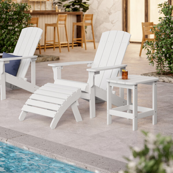 A white Lancaster Table & Seating Adirondack footrest next to a pool.