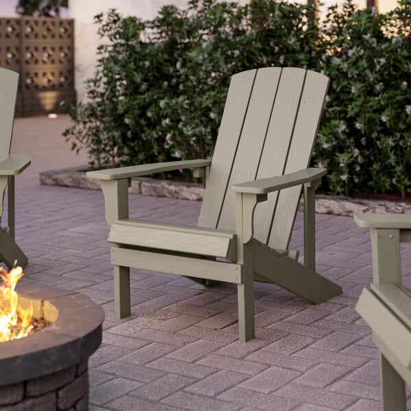 Three Lancaster Table & Seating gray modern Adirondack chairs on a brick patio.