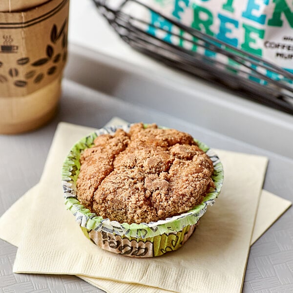 A brown Abe's vegan gluten-free coffee cake muffin in a green paper cup on a napkin.