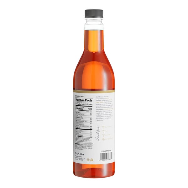 A close up of a bottle of Capora Peach Flavoring Syrup with a label.
