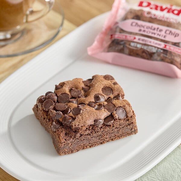 An Individually wrapped David's Cookies chocolate chip brownie on a plate.