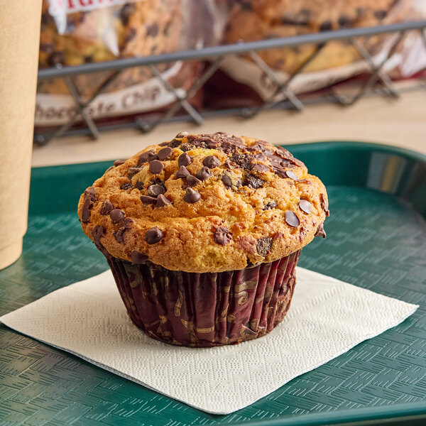 An individually wrapped David's Cookies chocolate chip muffin on a napkin.