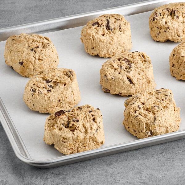 A tray of David's Cookies Preformed Decadent Oatmeal Walnut Chocolate Chunk cookie dough with six cookies on it.