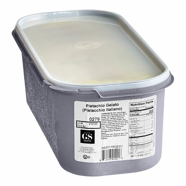 A white plastic G.S. Gelato Italiano container of Pistachio Gelato with a lid.