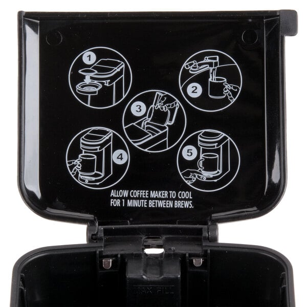 A black Hamilton Beach coffee maker on a counter with instructions.