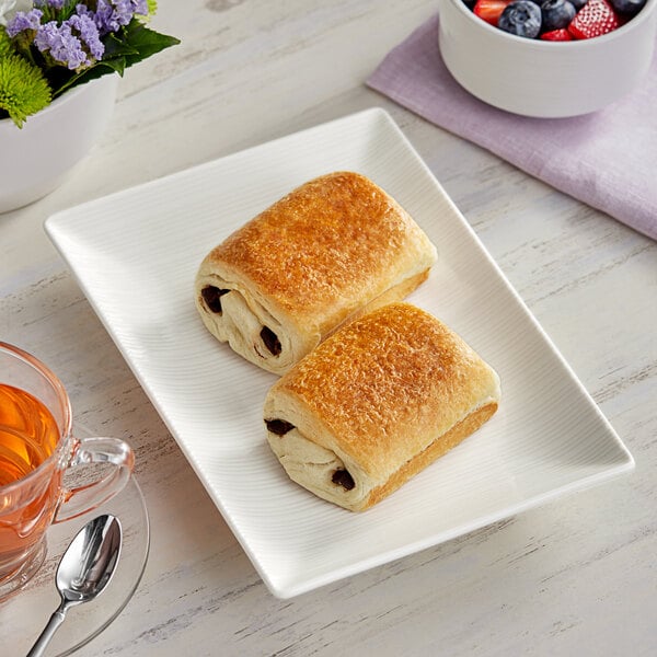 A plate of Brioche Gourmet frozen plant-based chocolate croissants with a cup of tea.