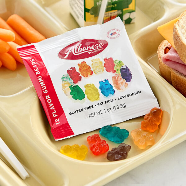 A tray with a sandwich and a bag of Albanese 12-Flavor Gummi Bears.