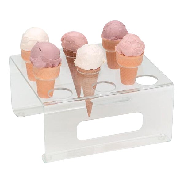 A Dispense-Rite clear acrylic ice cream cone holder with 9 holes on a counter filled with ice cream cones.