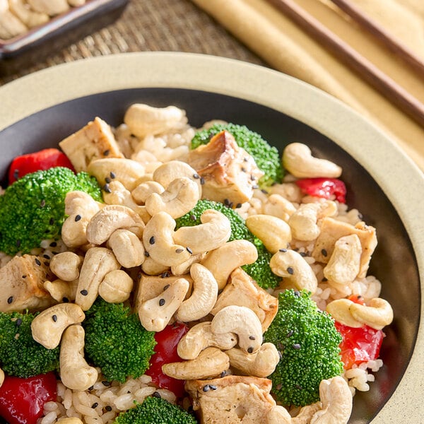 A bowl of food with rice, broccoli, and cashews.