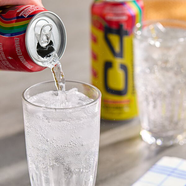 A person pouring C4 Energy Cosmic Rainbow soda into a glass of ice.