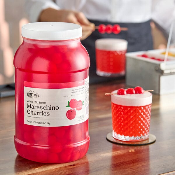 A large plastic jar of Hometown Provisions maraschino cherries without stems.