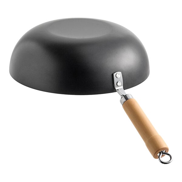A flat bottom carbon steel non-stick wok with a wooden handle.