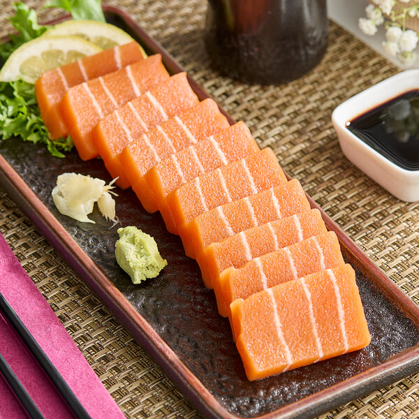 A plate of sliced orange vegan salmon sashimi.