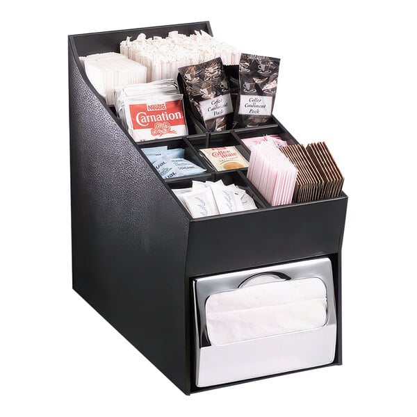 A black Dispense-Rite countertop organizer with straws, stir sticks, condiments, and napkins.