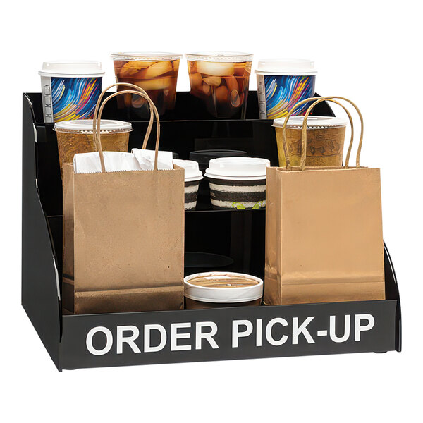 A black Dispense-Rite order pickup stand with a group of coffee cups and bags.