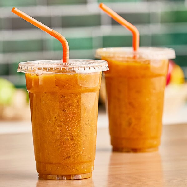 Two plastic cups of Fresh Blends mango beverage with straws on a counter.