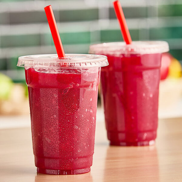 Two red drinks made with Fresh Blends Strawberry Beverage Base on a counter with straws.