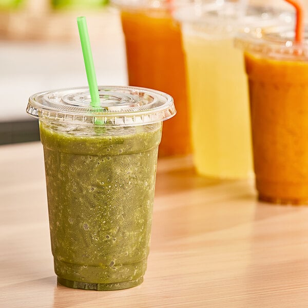 A table with plastic cups of green smoothies made with Fresh Blends Organic Green Goddess Beverage Base.