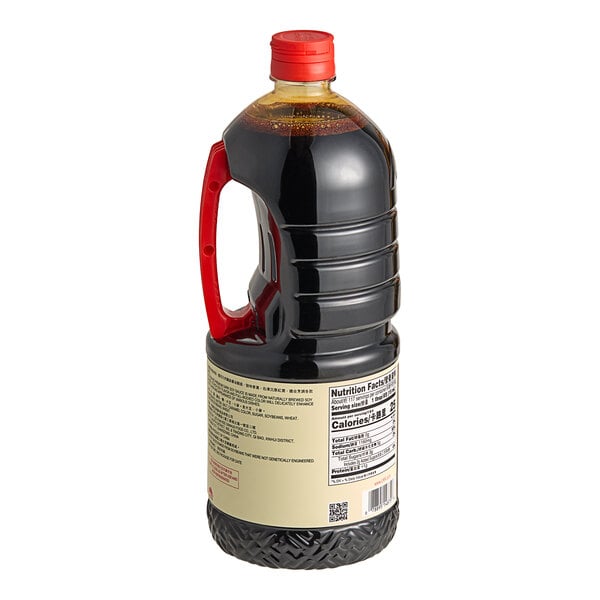 A close-up of a Lee Kum Kee Premium Dark Soy Sauce bottle with a red handle.
