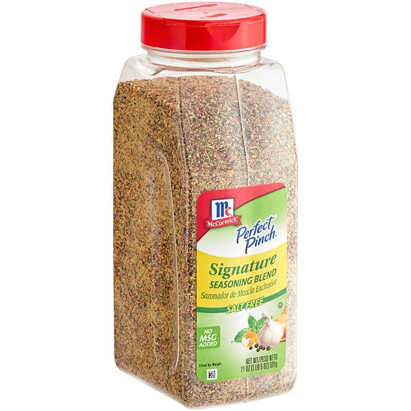 A clear container of McCormick Perfect Pinch Salt-Free Signature Seasoning Blend with a red lid and label.