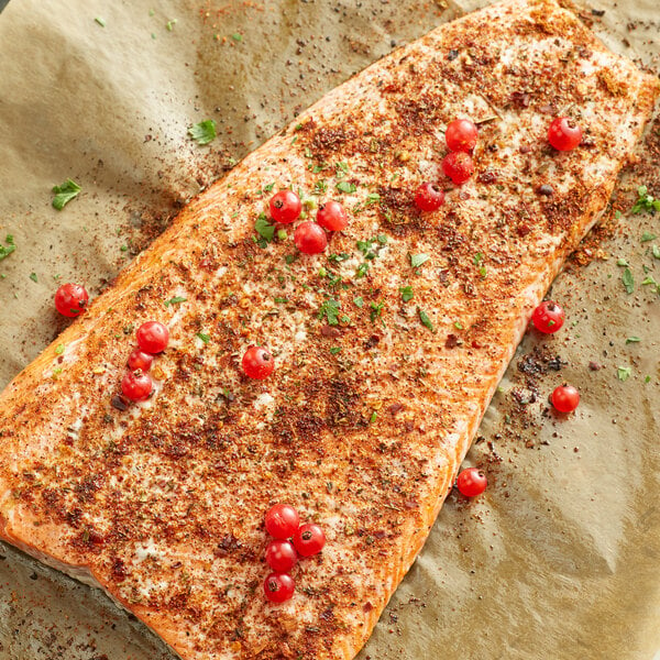 A piece of fish seasoned with McCormick Harissa with red berries on top.